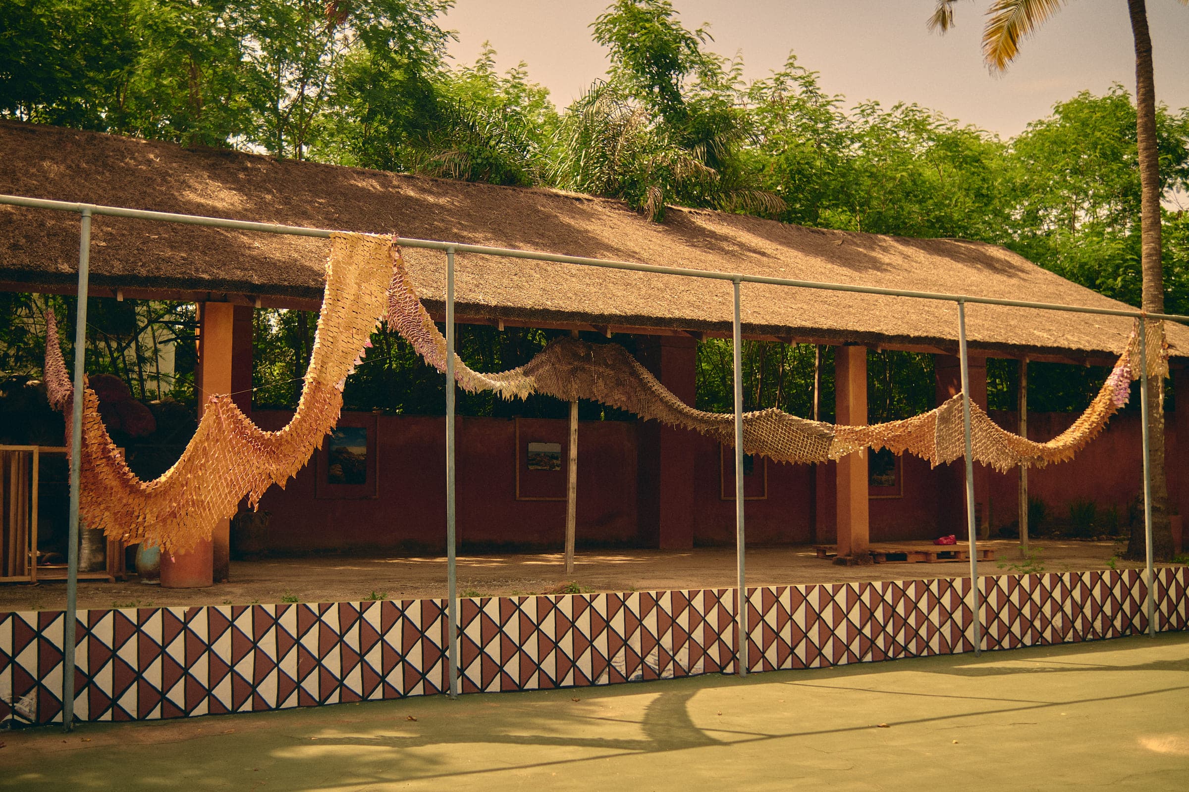 Dyed textiles draped along a fenced structure